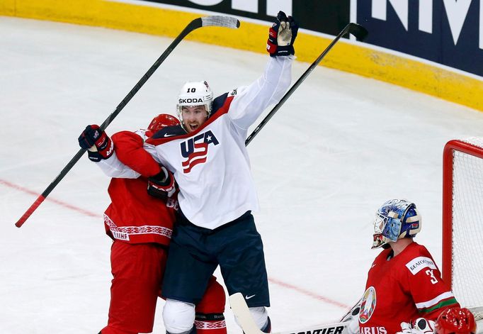 Jimmy Hayes of the U.S. (L) celebrates the goal of team mate Jacob Trouba (unseen) against goalkeeper Andrei Mezin of Belarus (R) during the second period of their men's