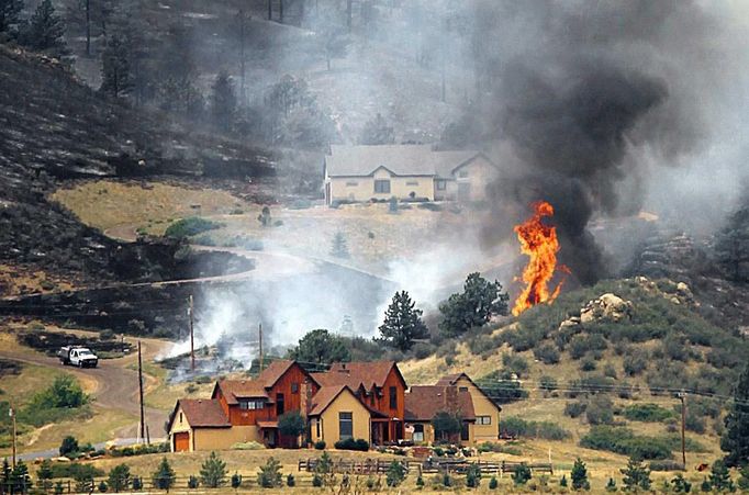 Smoke and flames encroach upon homes on the eastern front of the High Park fire near Laporte, Colorado June 10, 2012. A wind-driven wildfire burning in the rugged Colorado canyon spread out of control, forcing hundreds of people to evacuate and one person in the fire zone was reported missing, officials said on Sunday. REUTERS/Marc Piscotty (UNITED STATES - Tags: DISASTER ENVIRONMENT) Published: Čer. 10, 2012, 11:15 odp.