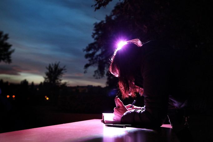 Lidé napřestávají zapisovat své vzkazy do kondolenčních knih ani po setmění.