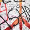 Lennonova zeď po třech měsících od malování - turisté, graffiti