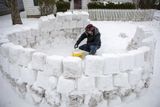 Studená fronta z Kanady přišla i do Spojených států. V úterý sníh pokrýval až 73 procent amerického území. Na fotografii si muž v americkém Kolumbusu staví iglú.