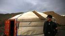 A member of the Mongolian neo-Nazi group Tsagaan Khass stands next to a 'ger', a traditional Mongolian tent, at a quarry, where they questioned a worker, southwest of Ulan Bator June 23, 2013. The group has rebranded itself as an environmentalist organisation fighting pollution by foreign-owned mines, seeking legitimacy as it sends Swastika-wearing members to check mining permits. Over the past years, ultra-nationalist groups have expanded in the country and among those garnering attention is Tsagaan Khass, which has recently shifted its focus from activities such as attacks on women it accuses of consorting with foreign men to environmental issues, with the stated goal of protecting Mongolia from foreign mining interests. This ultra-nationalist group was founded in the 1990s and currently has 100-plus members. Picture taken June 23, 2013. REUTERS/Carlos Barria (MONGOLIA - Tags: SOCIETY POLITICS TPX IMAGES OF THE DAY) ATTENTION EDITORS: PICTURE 24 OF 25 FOR PACKAGE 'MONGOLIA'S ENVIRONMENTAL NEO-NAZIS'. TO FIND ALL IMAGES SEARCH 'TSAGAAN KHASS' Published: Čec. 2, 2013, 9:58 dop.