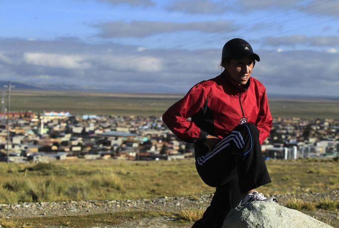 Marathon runner Gladys Tejeda, the first Peruvian athlete who qualified for the 2012 London Olympic Games, stretches before training at the San Cristobal mountain in the Andean province of Junin May 15, 2012. A private company will take Gladys' mother Marcelina Pucuhuaranga, 69, to London as part of the "Thank you Mom" program. For Pucuhuaranga, who received her first passport, it will be the first time travelling out of Peru. The program will take about 120 mothers of different athletes around the world to attend the games. Tejeda, the youngest of nine children, returned to her hometown to visit her mother and to focus on training where she will run more than 20 km every day in the highlands (over 4,105 meters above sea level). Picture taken May 15, 2012. REUTERS/Pilar Olivares(PERU - Tags: SPORT ATHLETICS OLYMPICS) Published: Kvě. 17, 2012, 6:26 odp.