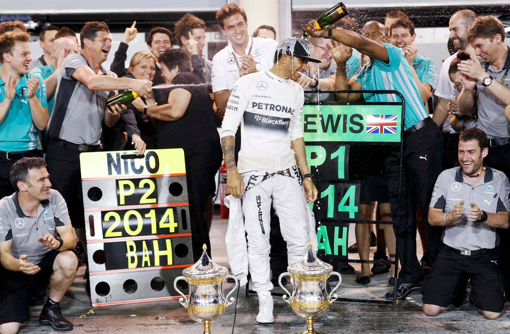 Mercedes Formula One driver Lewis Hamilton of Britain is sprayed with champagne by his team after his win in the Bahrain F1 Grand Prix at the Bahrain International Circuit (BIC) in Sakhir