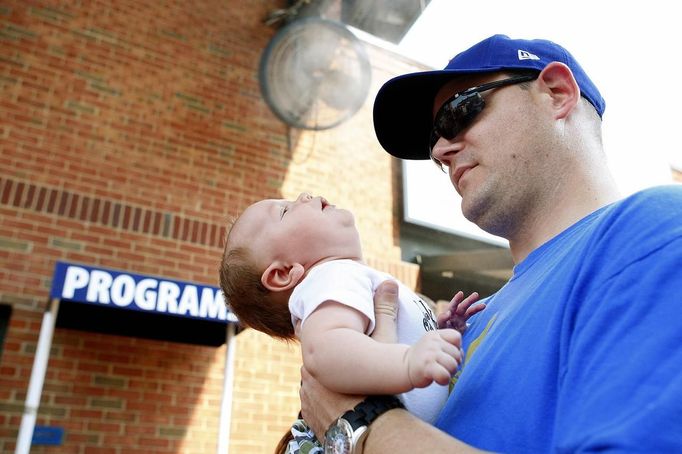 Cary McLaughlin holds his 2-month-old son Jack under the misting fans while attending a MLB National League baseball game between the Atlanta Braves and Washington Nationals at Turner Field in Atlanta, Georgia June 30, 2012. A record breaking heatwave has covered most of the country, with temperatures expected to reach 105 degrees Fahrenheit (41 degrees Celsius) in Atlanta. REUTERS/Tami Chappell (UNITED STATES - Tags: SOCIETY SPORT BASEBALL ENVIRONMENT) Published: Čer. 30, 2012, 10:55 odp.