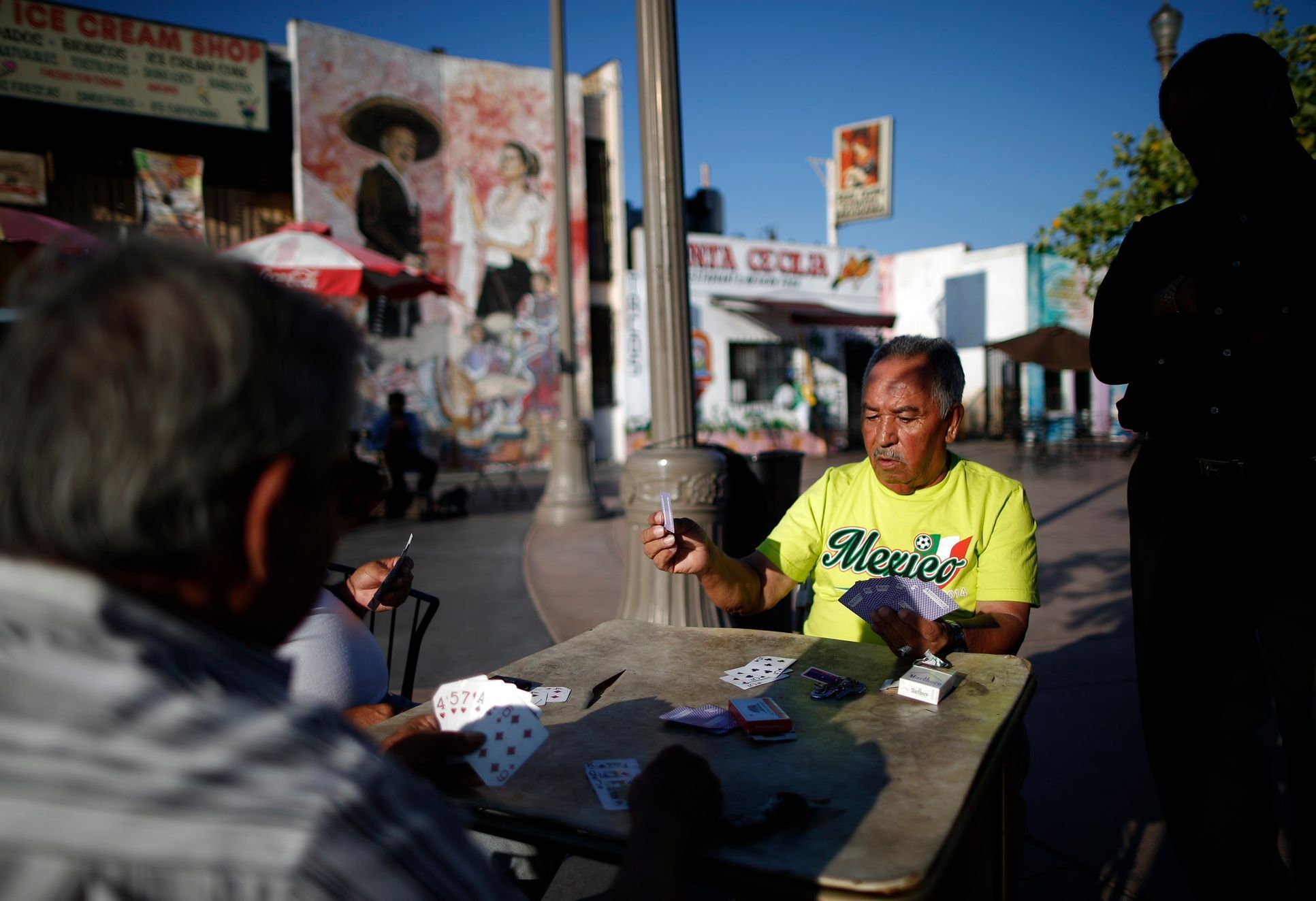Men play cards in Mariachi Plaza in the Boyle Heights area of Los Angeles