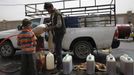 A boy buys fuel from a black market dealer amid an acute shortage of fuel in Sanaa, Yemen, July 1, 2015. Yemen is running critically short of imported food and fuel as