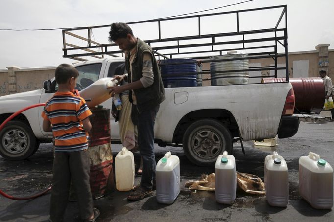 A boy buys fuel from a black market dealer amid an acute shortage of fuel in Sanaa, Yemen, July 1, 2015. Yemen is running critically short of imported food and fuel as