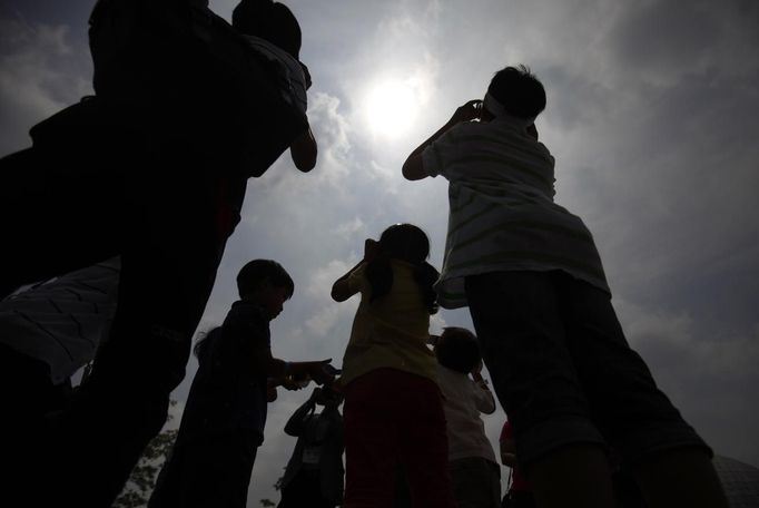 South Korean primary school students are silhouetted as they watch Venus passing between the Sun and the Earth at the Gwacheon National Science Museum in Gwacheon, south of Seoul, June 6, 2012. One of the rarest astronomical events occurs on Wednesday when Venus passes directly between the sun and Earth, a transit that won't occur again until 2117. REUTERS/Kim Hong-Ji (SOUTH KOREA - Tags: SOCIETY ENVIRONMENT SCIENCE TECHNOLOGY EDUCATION) Published: Čer. 6, 2012, 5:58 dop.