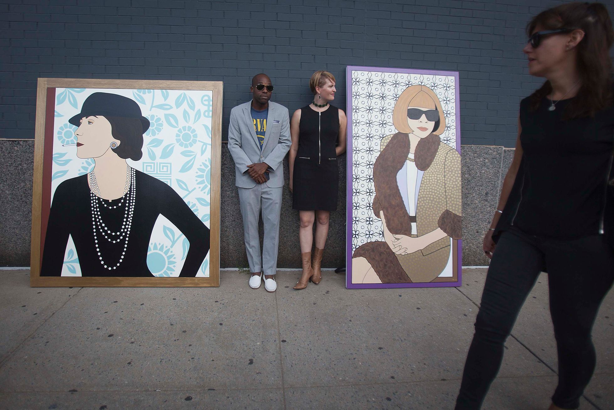 People stand next to some paintings following the  Diane von Furstenberg Spring/Summer 2015 collection show during New York Fashion Week
