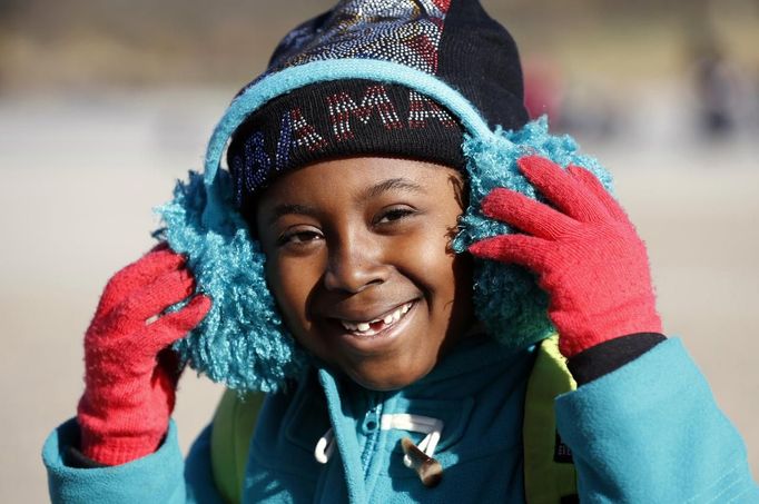 Jataun Flash, 7, of Orlando, Florida, sporting an Obama hat a day after attending the inauguration, adjusts her ear muffs against the cold while visiting the Lincoln Memorial, in Washington January 22, 2013. REUTERS/Kevin Lamarque (UNITED STATES - Tags: ENVIRONMENT SOCIETY) Published: Led. 22, 2013, 10:45 odp.