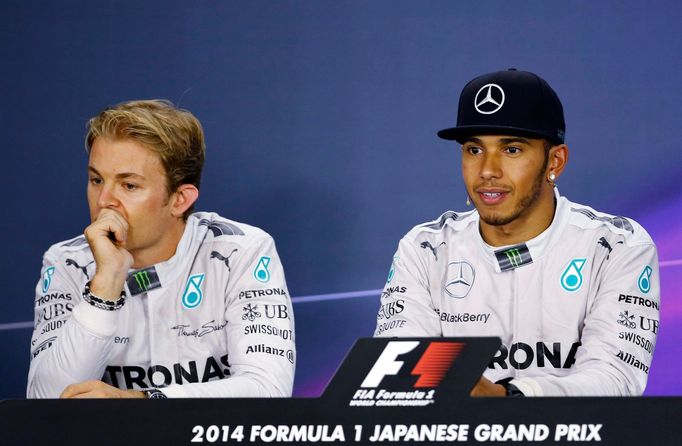 Mercedes Formula One driver Lewis Hamilton of Britain and teammate Nico Rosberg (L) of Germany attend a news conference after the Japanese F1 Grand Prix at the Suzuka Cir