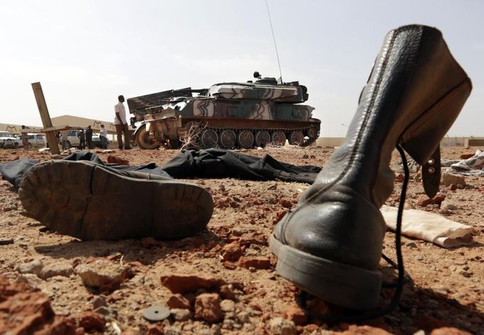 An abandoned pair of military boots are seen on the ground near two armoured vehicles in the recently liberated town of Konna January 26, 2013. REUTERS/Eric Gaillard (MALI - Tags: CIVIL UNREST CONFLICT MILITARY) Published: Led. 26, 2013, 2:23 odp.