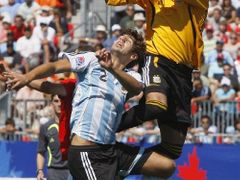 Argentinský brankář Romero (vpravo) likviduje vysoký míč, před ním skáče spoluhráč Federico Fazio.