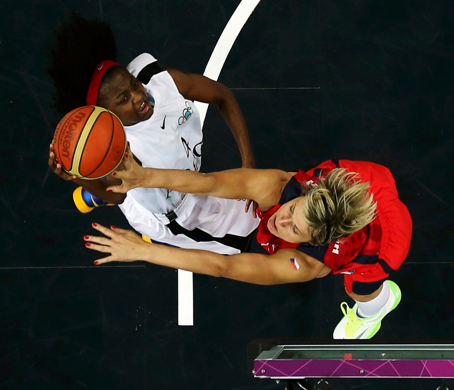 Česká basketbalistka Hana Horáková blokuje Angolku Madalenu Felixovou v utkání skupiny A na OH 2012 v Londýně.
