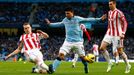 Sergio Agüero z Manchesteru City prochází mezi dvojicí ze Stoke Ryan Shawcross (vlevo) a Geoff Cameron.