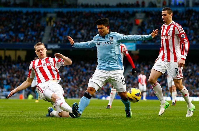 Sergio Agüero z Manchesteru City prochází mezi dvojicí ze Stoke Ryan Shawcross (vlevo) a Geoff Cameron.