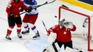 Switzerland's goalkeeper Leonardo Genoni saves as team mate Eric Blum (L) blocks Russia's Danis Zaripov (C) during the second period of their men's ice hockey World Champ