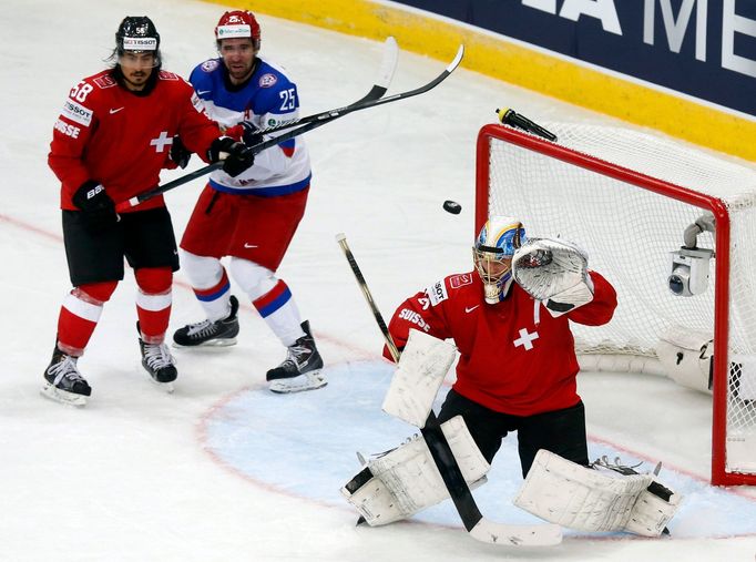 Switzerland's goalkeeper Leonardo Genoni saves as team mate Eric Blum (L) blocks Russia's Danis Zaripov (C) during the second period of their men's ice hockey World Champ