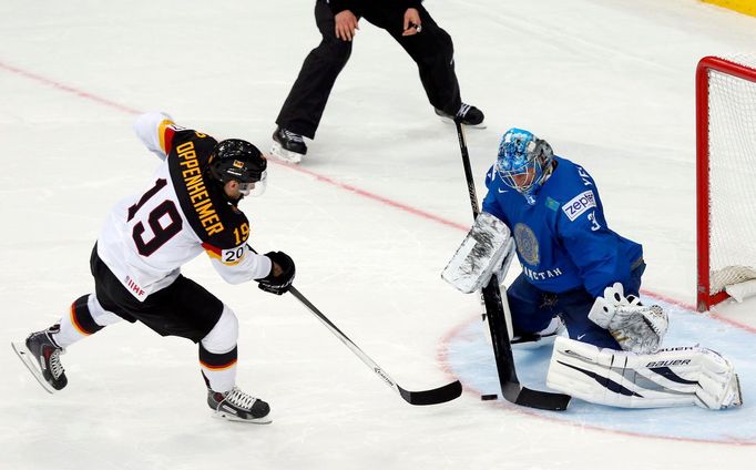 Kazakhstan's goalie Vitali Yeremeyev (R) fails to save a penalty goal in front of Germany's Thomas Oppenheimer (L) during a penalty shoot out during their men's ice hocke