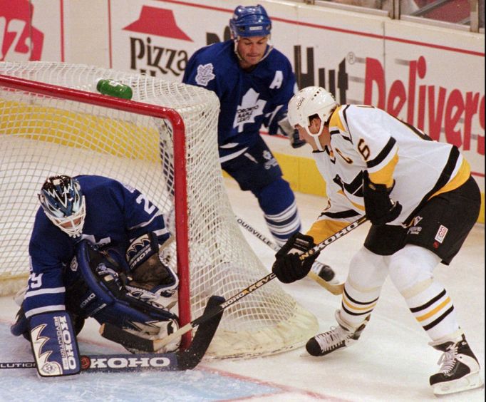 Mario Lemieux (vpravo) z týmu Pittsburgh Penguins v útočné akci,kterou likviduje brankář týmu Toronto Maple Leafs Felix Potvin.Za brankou obránce Toronta Dave Ellet.