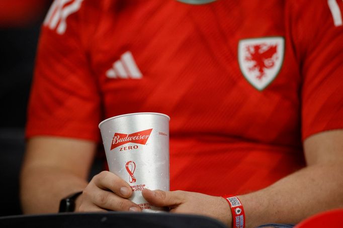 Fanoušek s kelímkem imitujícím nealkoholické pivo během zápasu MS 2022 USA - Wales