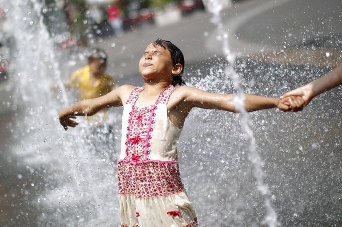 A girl plays with water fountains in a public square in Vienna, June 19, 2012. Temperatures are expected to rise up to 35 degrees Celsius (95 degrees Fahrenheit), Austria's national weather service agency ZAMG reported. REUTERS/Lisi Niesner (AUSTRIA - Tags: ENVIRONMENT SOCIETY) Published: Čer. 19, 2012, 3:24 odp.