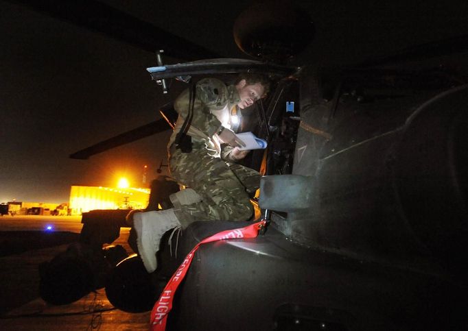 Britain's Prince Harry prepares his Apache helicopter before a night mission at Camp Bastion, southern Afghanistan in this photograph taken December 11, 2012, and released January 21, 2013. The Prince, who is serving as a pilot/gunner with 662 Squadron Army Air Corps, is on a posting to Afghanistan that runs from September 2012 to January 2013. Photograph taken December 11, 2012. REUTERS/John Stillwell/Pool (AFGHANISTAN - Tags: MILITARY POLITICS SOCIETY ROYALS CONFLICT) Published: Led. 21, 2013, 7:38 odp.