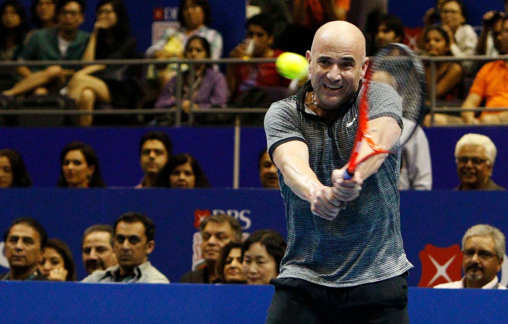 Singapore Slammers' Andre Agassi of the U.S. hits a return to Manila Mavericks' Mark Philippoussis of Australia during their men's singles match at the International Premier Tennis League (IPTL) in Si