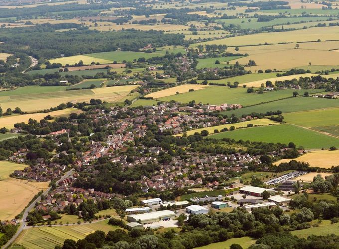 Letecký pohled na vesnici Woolpit v hrabství Suffolk, Velká Británie. Snímek z roku 2015 ukazuje moderní podobu dějiště středověké legendy.