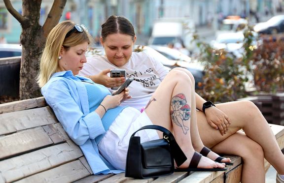 Moskvanky sledují mobilní telefon. Ilustrační foto.