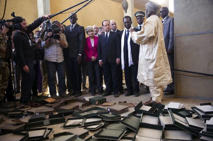 France's President Francois Hollande (5thR) flanked by Mali's interim president Dioncounda Traore (3dR), French Foreign Affairs minister Laurent Fabius (4thR) and UNESCO general director Irina Bokova (C) visit the archives where documents were burnt in Timbuktu during his one-day visit in Mali, February 2, 2013. Islamists had torched the building housing priceless ancient manuscripts as they fled the town. French President Hollande flew to Mali on Saturday to support French troops fighting Islamist rebels in the Sahel nation and he visited the famed ancient city of Timbuktu that was recaptured from al Qaeda-allied fighters six days ago. REUTERS/Fred Dufour/Pool (MALI - Tags: POLITICS CONFLICT CIVIL UNREST) Published: Úno. 2, 2013, 12:55 odp.