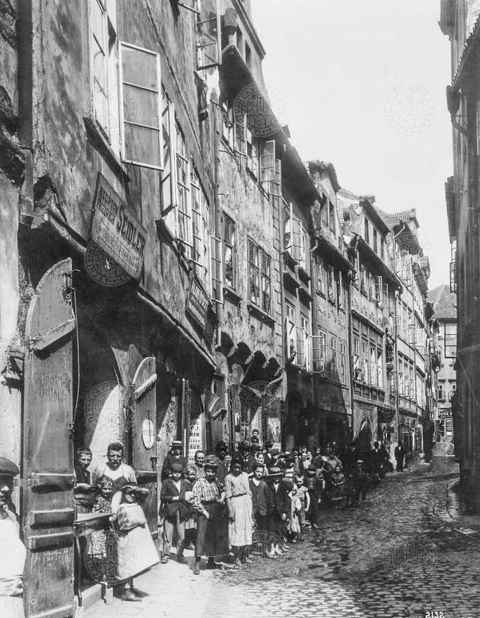 Pohled do Platnéřské ulice s domy zleva čp. 112, 113, 115, 117, 119 ("U Železného muže") na Starém Městě krátce před zbořením. Rok 1908