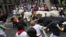 Runners sprint alongside Cebada Gago ranch fighting bulls on Santo Domingo street during the third Running Of The Bulls at the San Fermin festival in Pamplona July 9, 2012. Three people, two from Britain and one from the U.S. were gored by Fugado (Runaway), a 545 kg (1,199 pounds) bull that broke from the pack after falling in Santo Domingo in a run that lasted three minutes and thirty-eight seconds. REUTERS/Joseba Etxaburu (SPAIN - Tags: ANIMALS SOCIETY) Published: Čec. 9, 2012, 9:43 dop.