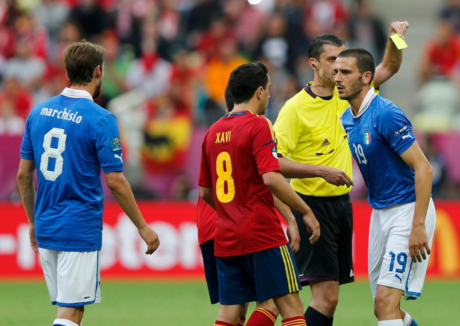 Claudio Marchisio, Xavi Hernandez, rozhodčí Viktor Kassai a Leonardo Bonucci v utkání základní skupiny mezi Španělskem a Itálií na Euru 2012