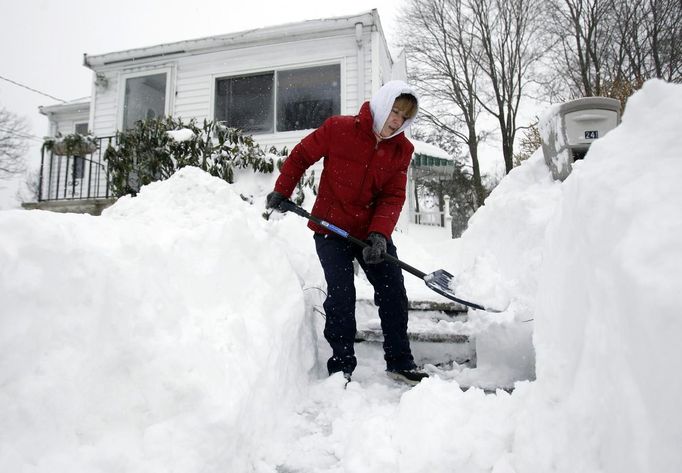 Donnalyn Sullivan shovels out her front steps during a blizzard in Medford, Massachusetts February 9, 2013. A blizzard pummelled the Northeastern United States, killing at least one person, leaving hundreds of thousands without power and disrupting thousands of flights, media and officials said. REUTERS/Jessica Rinaldi (UNITED STATES - Tags: ENVIRONMENT) Published: Úno. 9, 2013, 2:50 odp.