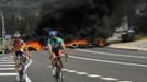 Riders pedal on the N-630 road past a fire barricade set up by miners in La Robla, near Leon, northern Spain June 20, 2012. The miners were protesting against the government's proposal to decrease funding for coal production. REUTERS/Eloy Alonso (SPAIN - Tags: CIVIL UNREST POLITICS BUSINESS EMPLOYMENT SPORT CYCLING) Published: Čer. 20, 2012, 1:02 odp.