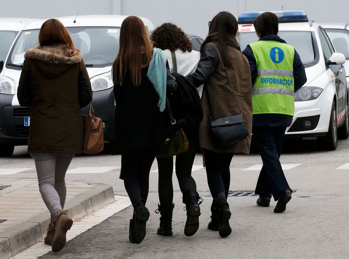 An assistant (R) escorts people believed to be family members of those killed in Germanwings plane crash as they arrive at Barcelona's El Prat airport March 24, 2015.