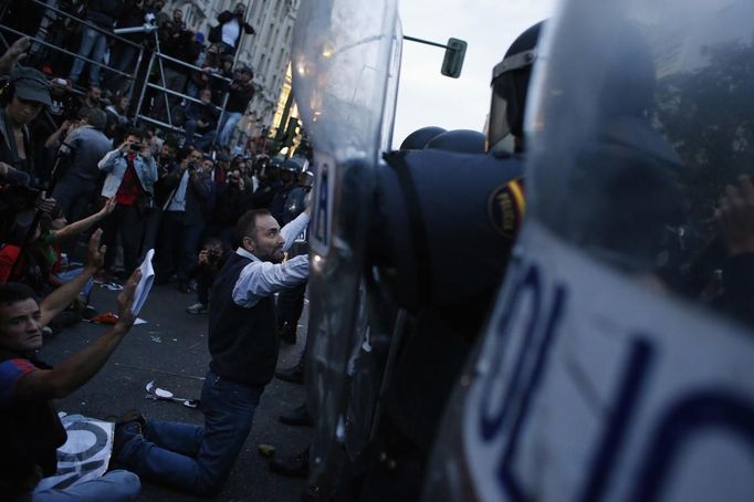 A demonstrator kneels before the riot police outside the Spanish parliament in Madrid, September 25, 2012. Protesters clashed with police in Spain's capital on Tuesday as the government prepares a new round of unpopular austerity measures for the 2013 budget that will be announced on Thursday. REUTERS/Susana Vera (SPAIN - Tags: CIVIL UNREST POLITICS BUSINESS) Published: Zář. 25, 2012, 8:48 odp.