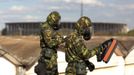 Brazilian army soldiers wearing chemical suits participate in an anti-terror simulation exercise as part of the preparation for the upcoming 2013 FIFA Confederations Cup in Brasilia. May 22, 2013. About 100 soldiers took part in the exercise which include preventive strikes against chemical, biological and radiological weapons conducted around Mane Garrincha National Stadium, according to an official statement. REUTERS/Ueslei Marcelino (BRAZIL - Tags: SPORT SOCCER MILITARY) Published: Kvě. 22, 2013, 9:26 odp.