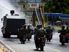 Vodní dělo zasahuje při pouličních bouřích v Caracasu, vyvolaných situací ve věznici El Rodeo.