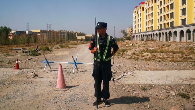 Čínský policista hlídkuje poblíž internačního tábora pro Ujgury v provincii Sin-ťiang