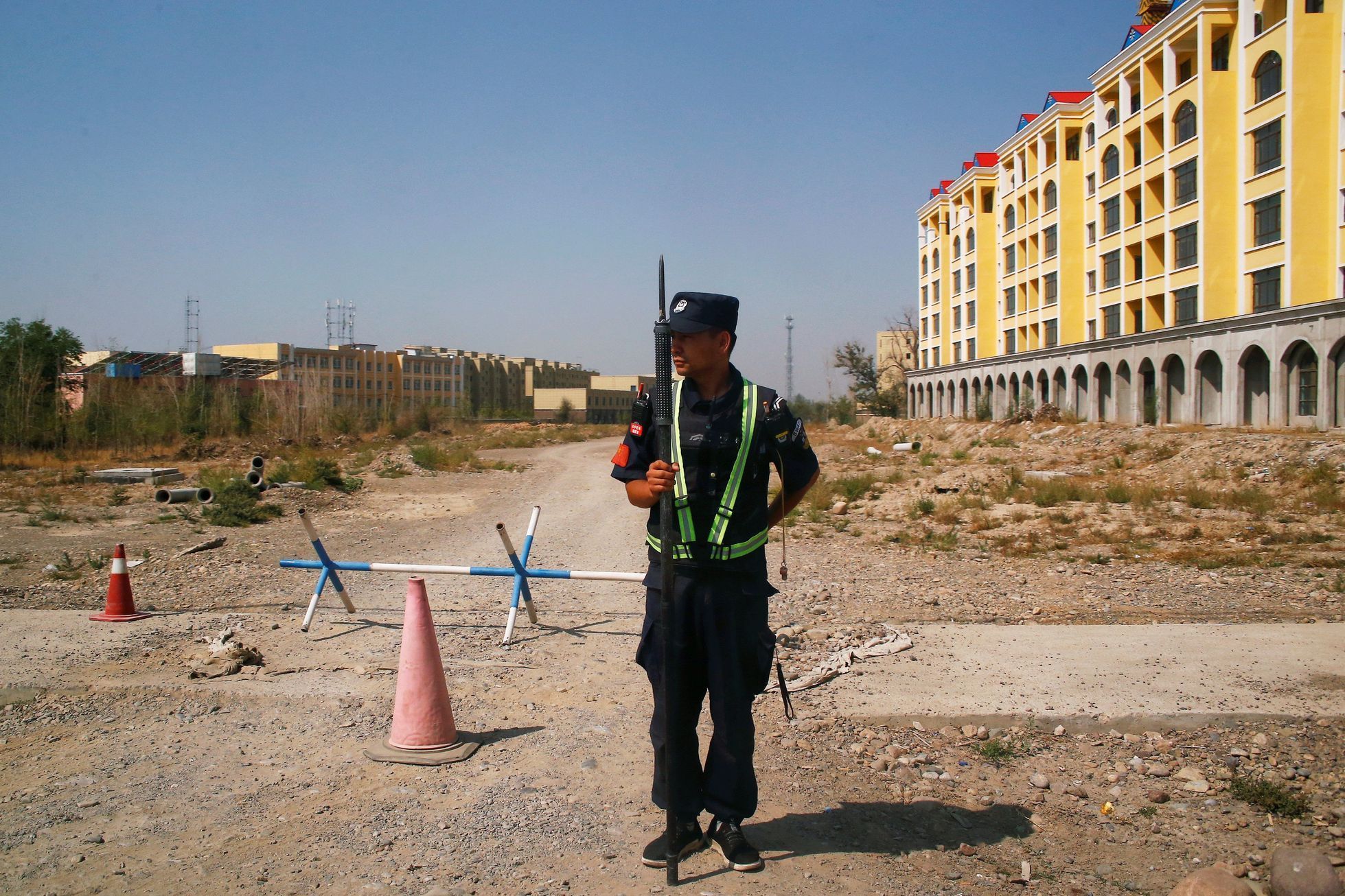 Čínský policista hlídkuje poblíž internačního tábora pro Ujgury v provincii Sin-ťiang
