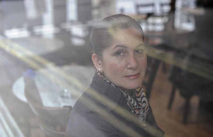 Katarina Germanou poses for a photograph in the Byzantium Cafe where she works as a waitress in west London