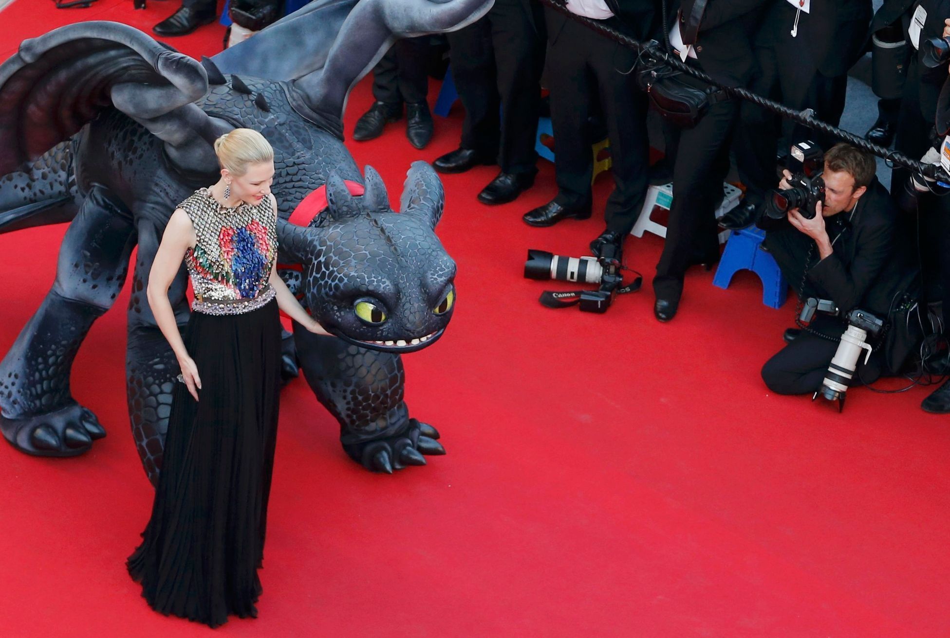 Actress Cate Blanchett poses on the red carpet with a figure of Toothless the Dragon character as she arrives for the screening of the film &quot;How to Train Your Dragon 2&quot; out of competition at