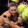 Sharapova of the Manila Mavericks team poses with fans after beating Mladenovic of the UAE Royals team in their women's singles tennis match at the IPTL competition in Manila