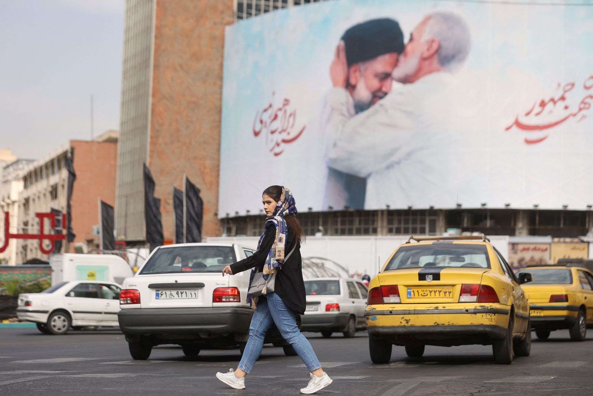 Íránská žena prochází v Teheránu kolem billboardu s fotografií zesnulého íránského prezidenta Raísího.