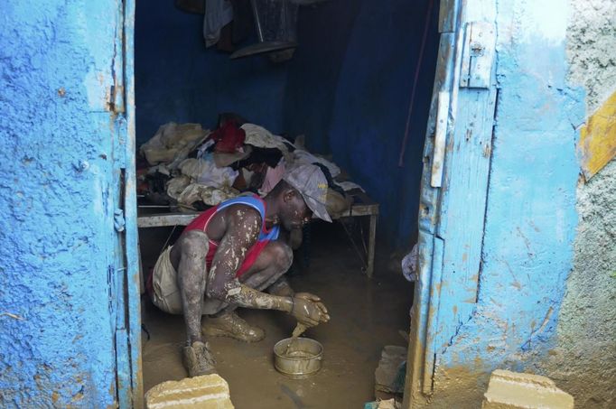 A Haitian man whose house was flooded due to Tropical Storm Isaac tries to remove mud from its floor in an area outside of Port-au-Prince August 26, 2012. Tropical Storm Isaac left six dead in Haiti, still recovering from a 2010 earthquake, and at least three missing in the Dominican Republic after battering their shared island of Hispaniola on Saturday. REUTERS/Swoan Parker (HAITI - Tags: DISASTER SOCIETY ENVIRONMENT) Published: Srp. 26, 2012, 4:38 odp.