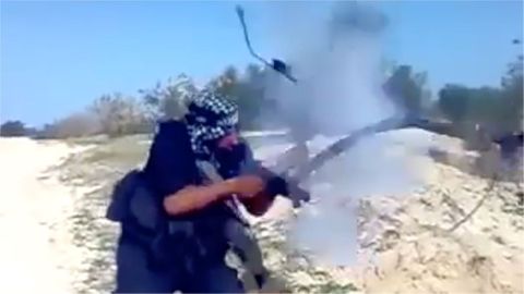 Bojovník IS střílí ze samopalu. Ten mu v rukou exploduje