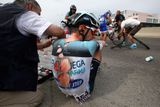 Jeden ze závodníků stáje Omega Pharma-Quick Step je ošetřován po hromadném pádu pět kilometrů před cílem...